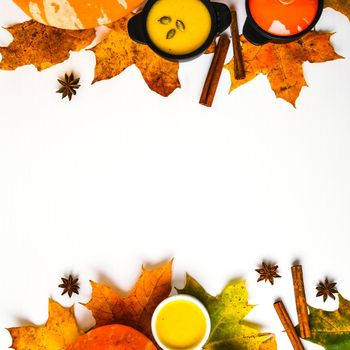 Autumn food. Frame of pumpkin puree soup, leaves. Top view. Autumn harvest, pumpkins, leaves on grey as abstract background. View from above. Thanksgiving day. Flat lay. Copy space