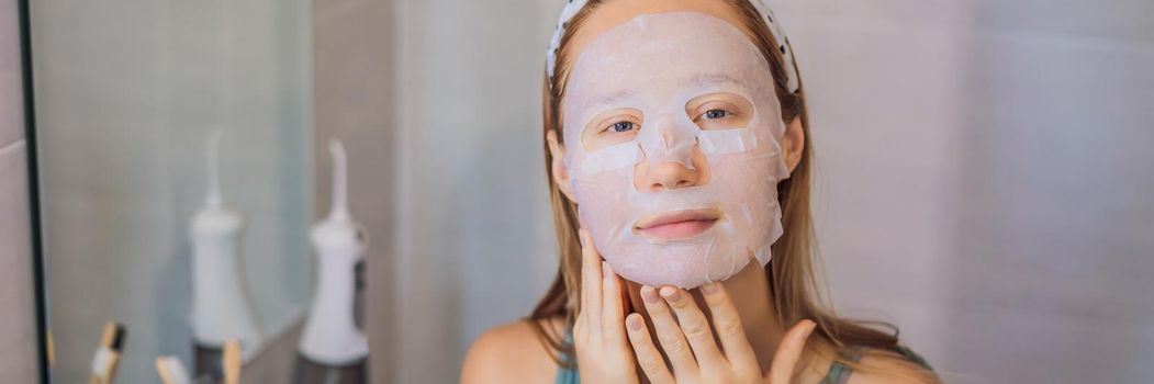 Young red-haired woman doing facial mask sheet. Beauty and Skin Care Concept. BANNER, LONG FORMAT