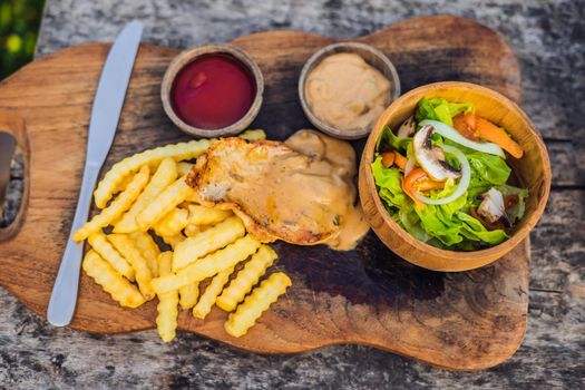 French fries, green salad with champignons and chicken breast. Lifestyle food.