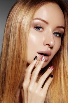 Beautiful young woman with clean skin, beautiful straight shiny hair, fashion makeup. Glamour make-up, perfect shape eyebrows. Portrait sexy blondy. Beautiful smooth hairstyle. Shiny nail polish.