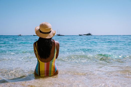 Golfo di Orosei Sardina, Asian women on the beach Sardinia Italy, a young girl on vacation Sardinia Italy, woman playing in the ocean with crystal clear blue water,