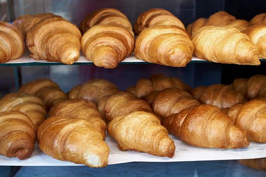 Many fresh croissants on the store shelf