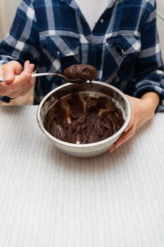 Preparation for baking chocolate brownie, dough in a metal bowl. Cooking cookies at home