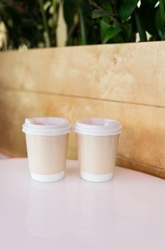 Two paper coffee cups in a cafe, coffee to go concept. Walks in the open air