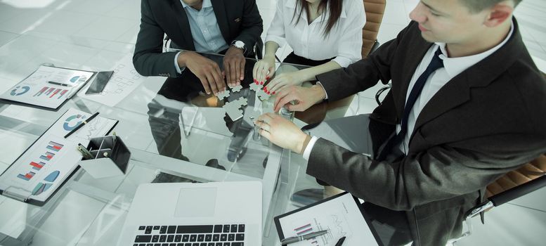 group of business people assembling the pieces of the puzzle.business concept