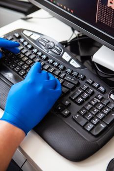 A doctor in blue gloves quickly collects data about a patient. The concept of healthcare and taking care of your health. Workplace of a doctor, online consultation