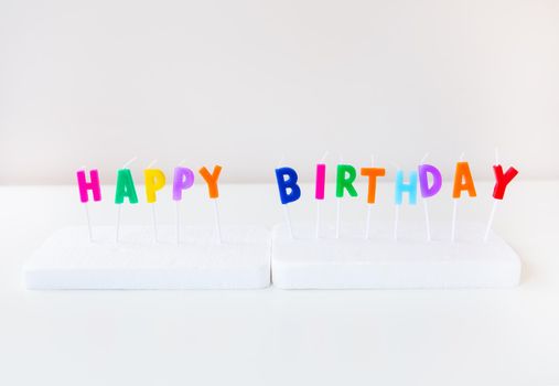 Colorful candles with the inscription Happy Birthday isolated on a white background. Holiday and surprise concept