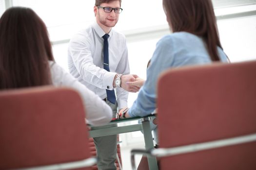 handshake Manager and client over the Desk in the office.