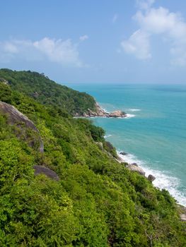 Rocky rock over beautiful clear sea and island, view from Kho Phangan, Thailand.