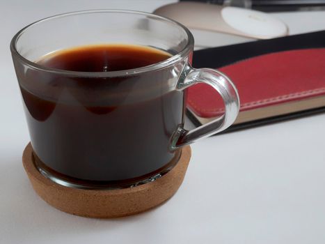 Workplace with notebook, pen and glass coffee mug on white background.