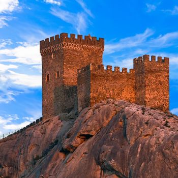 Medieval Genoese fortress against blue sky with clouds. The Crimean Peninsula, Ukraine.