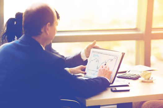 Close-up of female and male hands pointing at business document while discussing it