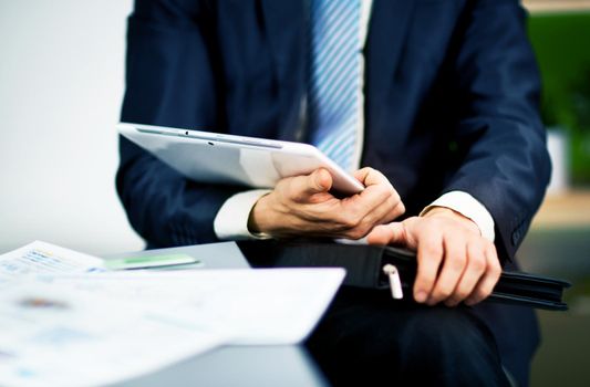 Businessman hands are holding the touch screen device.