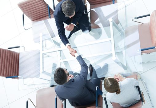 Top view Handshake across the table. Meeting in the conference room