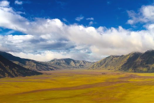 Volcanic landscape against blue sky with clouds. Bromo Tengger Semeru National Park, East Java, Indonesia