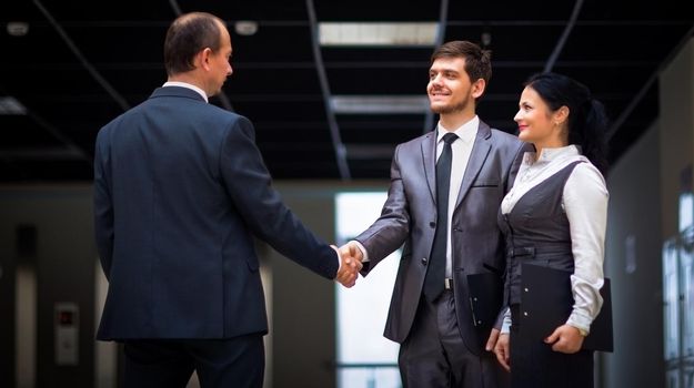 cheerful business men shaking hands