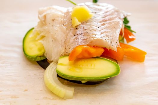 White fish fillet with vegetables in rustic style. Healthy eating: cooked fish fillet with vegetables garnish. Diet food with white fish and vegetables. Steam vegetables with roasted zander fillet