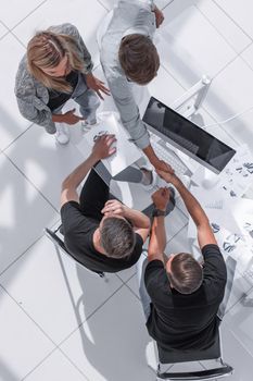 young businessmen in a modern office sign a contract and shake hands with each other.