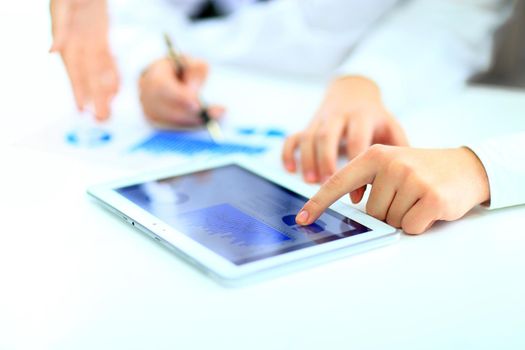 Image of human hand pointing at touchscreen with business document