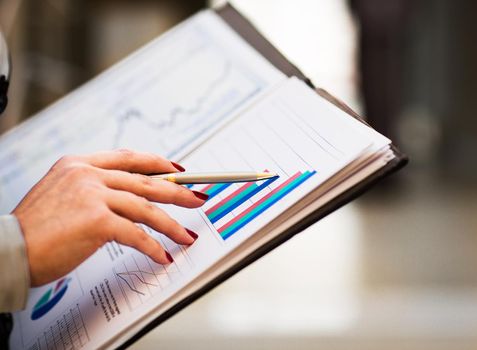 Close-up of female and male hands pointing at business document while discussing it