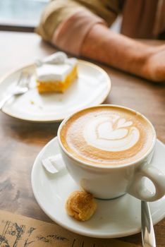 a cup of late coffee with flower shape design on top at cafe .