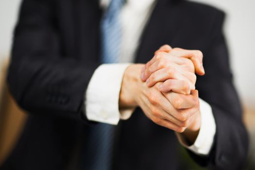 Businessman at the office with his hands folded. Willingness to friendship and cooperation.