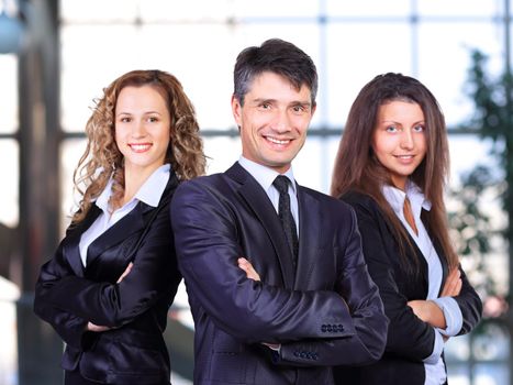 A business team with pretty leader in front looking at camera and smiling
