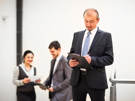 Happy mature business man looking at camera with satisfaction at office
