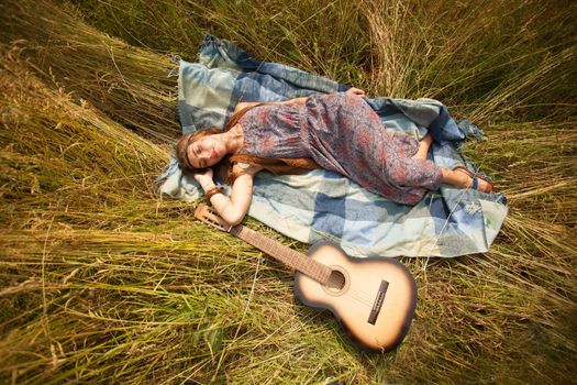 Beautiful young hippie girl has a rest on the nature.