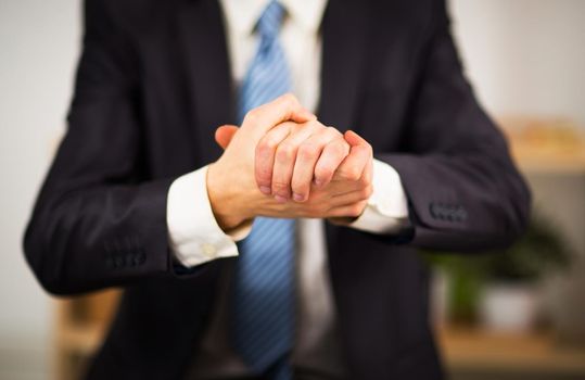 Businessman at the office with his hands folded. Willingness to friendship and cooperation.