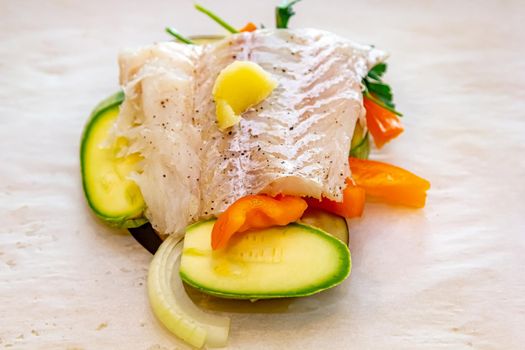 White fish fillet with vegetables in rustic style. Healthy eating: cooked fish fillet with vegetables garnish. Diet food with white fish and vegetables. Steam vegetables with roasted zander fillet