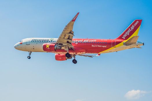 Vietnam, NhaTrang, 04.05.2020: Coronavirus is over. Quarantine weakened. Take off the mask. Now you can travel. Modern airplane vietjet in the sky near Airport. takes off or landing.