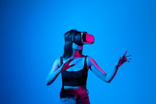 Brunette woman with VR headset touching something what she see in virtual world. Futuristic technology