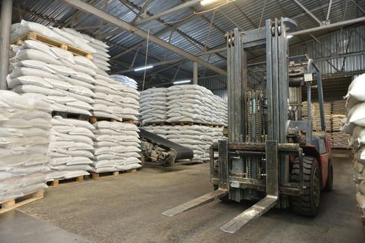 Forklift in a warehouse with wheat in sacks.