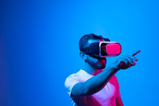 Modern architect, designer using virtual reality glasses at workplace. Designer working in augmented reality vr studio. Man working in VR goggles on a studio background