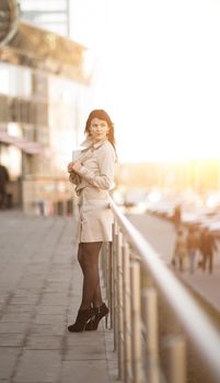 Portrait of a successful business woman on a modern office building background. The photo has an empty space for your text