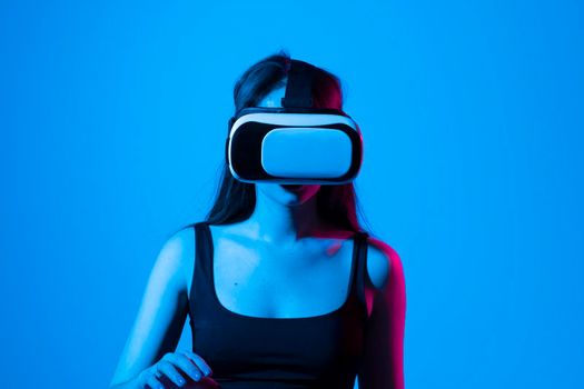 Smile happy woman getting experience using vr-headset glasses of virtual reality much gesticulating hands on gray background. Girl spend shes time in metaverse