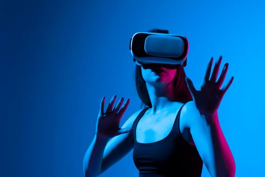 Woman in VR headset looking up at the objects in virtual reality while playing a game or watching 3d movie. Future technology concept