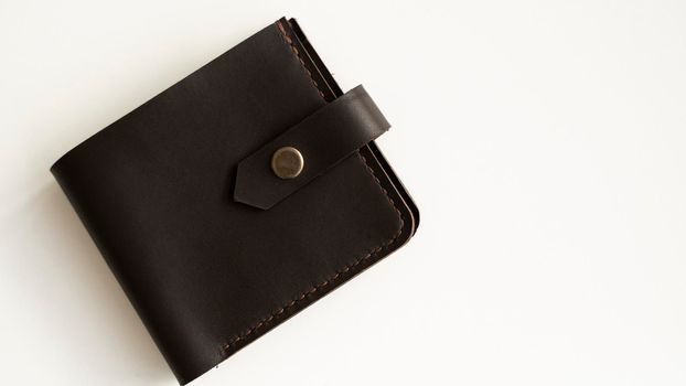 Top view of brown empty man's black handmade genuine leather wallet for banknotes and credit cards isolated on white background. Selective focus, copy space, Close up