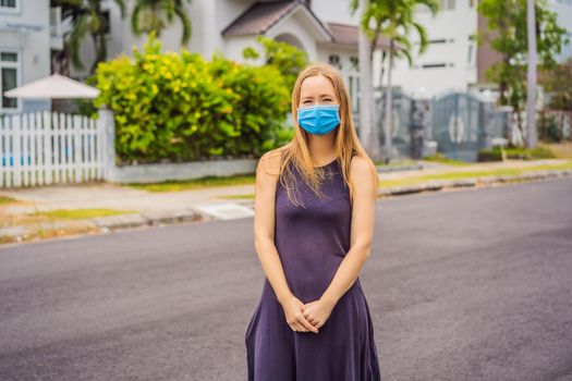 Woman in a small town in a medical mask because of a coronovirus epidemic.