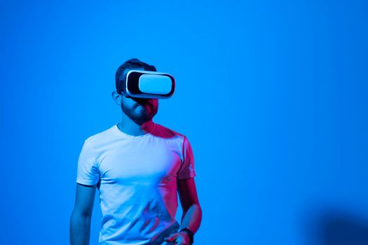 Bearded young man wearing virtual reality goggles and interacting with a virtual environment. Future technology concept. Metaverse