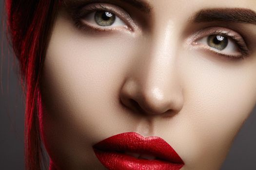 Closeup portrait with of beautiful woman face. Red color of fashion lip makeup, clean shiny skin and mat lipstick. Makeup and cosmetic. Beauty style