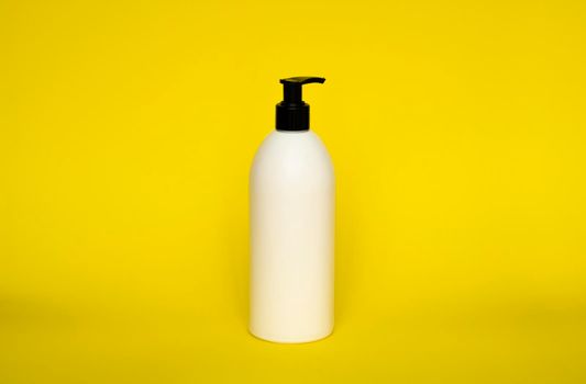 Large white plastic bottle with pump dispenser on yellow background. Mock up template for design