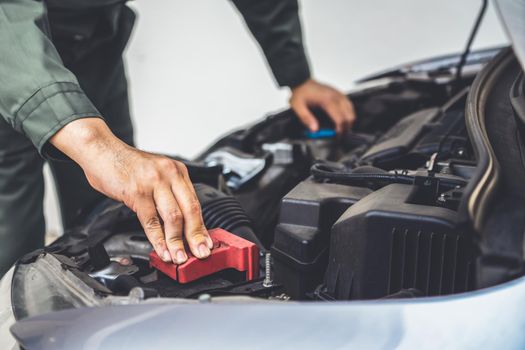 Professional mechanic hand providing car repair and maintenance service in auto garage. Car service business concept.