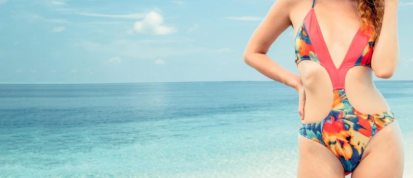 Happy young woman wearing swimsuit at tropical sand beach resort in summer for holiday travel vacation.