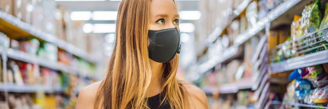 Alarmed female wears medical mask against coronavirus while grocery shopping in supermarket or store- health, safety and pandemic concept - young woman wearing protective mask and stockpiling food. BANNER, LONG FORMAT