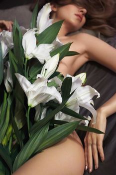 Perfect female figure with white flowers lily. Sexy body of luxury woman. Epilation and spa. Spring or Summer photo