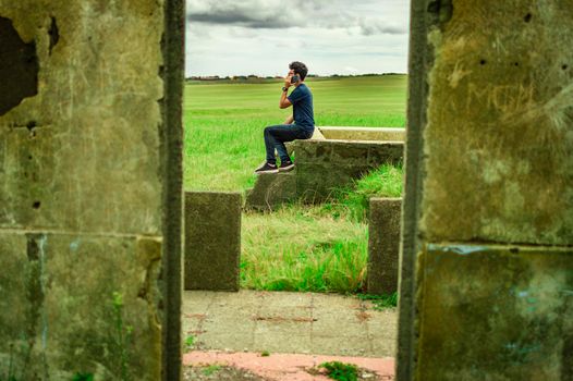 Man calling by cell phone, young man in the field calling by cell phone