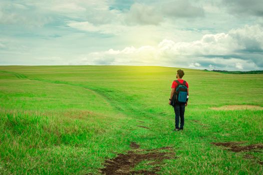 Adventurous man in the field, man with backpack in the field looking