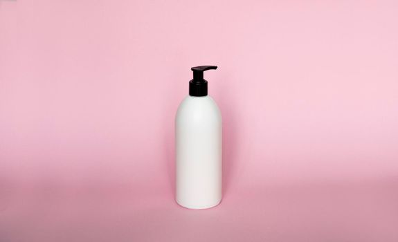 Large white plastic bottle with pump dispenser on pink background. Mock up template for design